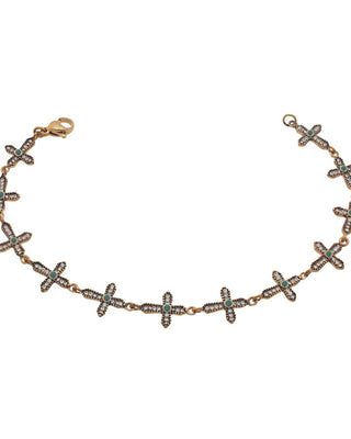 Gold bracelet featuring cross-shaped links, Each cross is adorned with alternating white zircon and green, emerald crystals